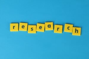 Yellow letter tiles spelling “research” on a blue background