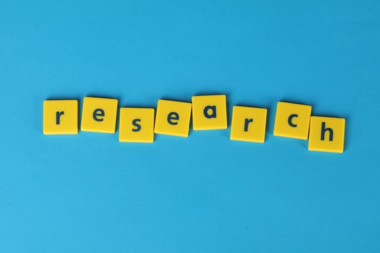 Yellow letter tiles spelling “research” on a blue background