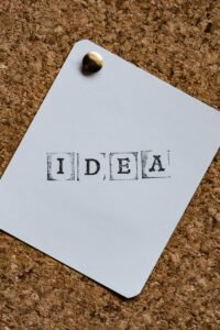 White paper stamped “IDEA” pinned to a corkboard
