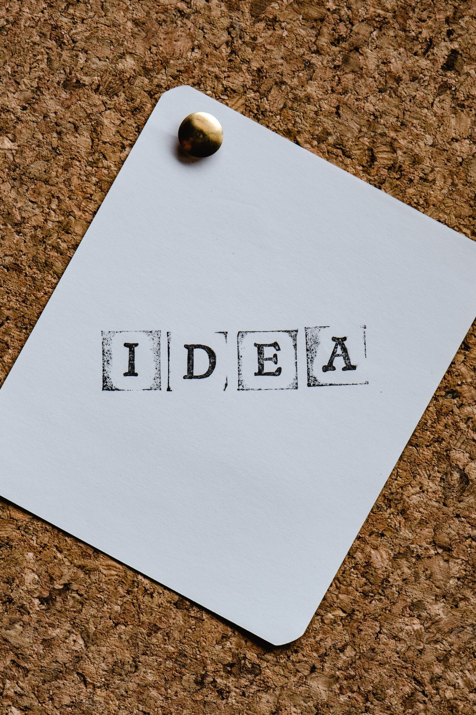 White paper stamped “IDEA” pinned to a corkboard