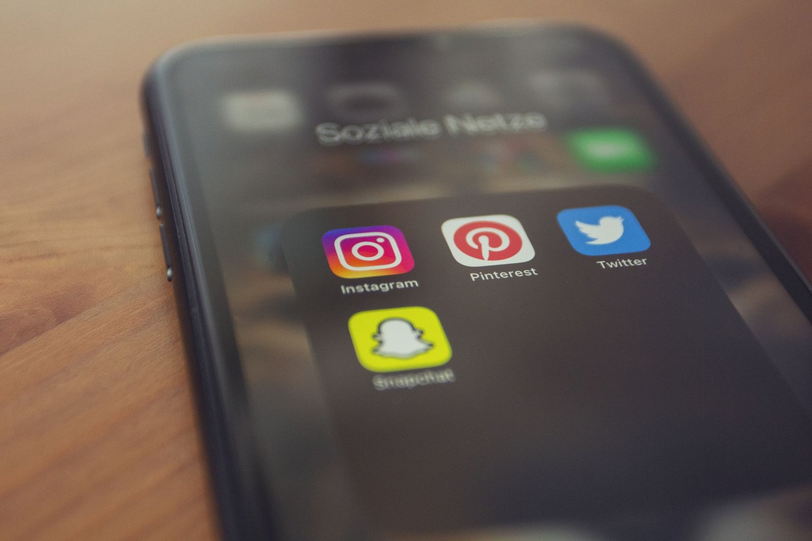 A smartphone displaying the Pinterest app alongside other social media applications, representing Pinterest as a visual discovery and traffic platform for bloggers.